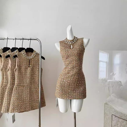 Платье без рукавов, расшитое бисером и приталенное.