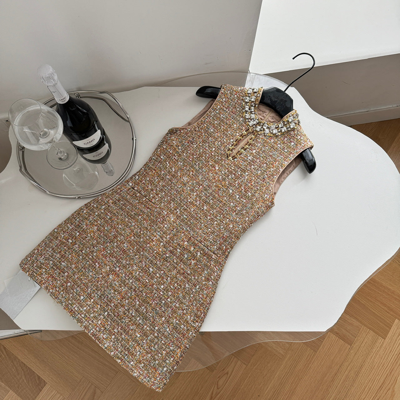 Платье без рукавов, расшитое бисером и приталенное.