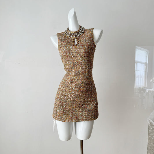 Платье без рукавов, расшитое бисером и приталенное.