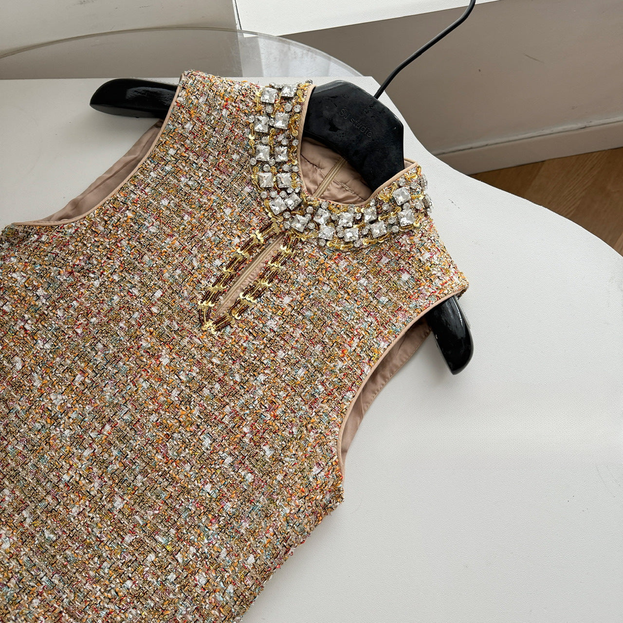 Платье без рукавов, расшитое бисером и приталенное.